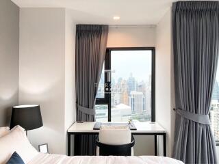 Modern bedroom with city view from large window