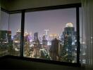 View from a high-rise building window at night showcasing city lights