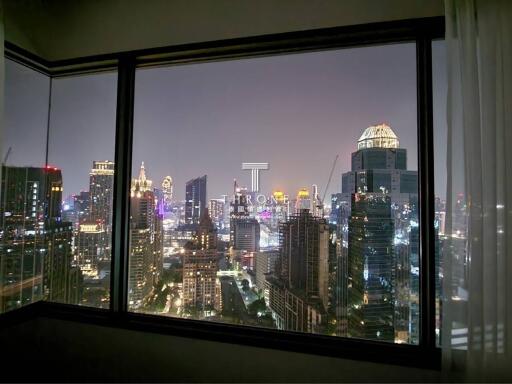 View from a high-rise building window at night showcasing city lights
