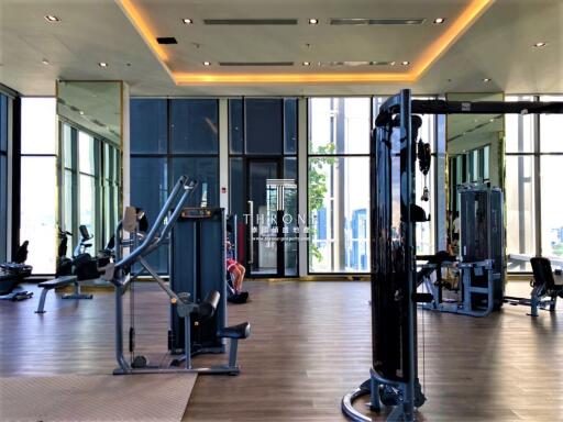 Modern gym facility in residential building with various exercise machines and ample lighting