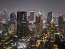 Aerial view of a bustling city at night with illuminated skyscrapers