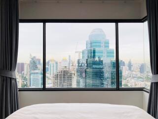 Bedroom with large window overlooking cityscape