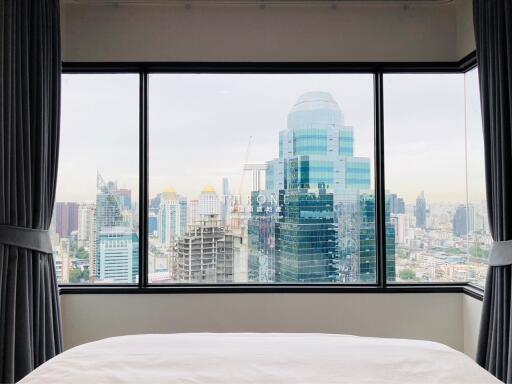Bedroom with large window overlooking cityscape