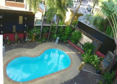 Aerial view of an inviting outdoor swimming pool surrounded by lush greenery and comfortable seating areas
