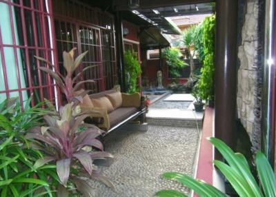 Spacious patio area with comfortable seating and surrounded by greenery