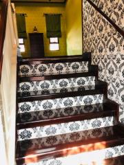 Elegant staircase with patterned wallpaper and wooden banister