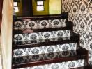 Elegant staircase with patterned wallpaper and wooden banister