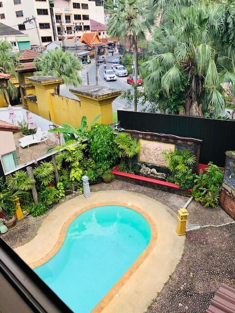 Overhead view of outdoor area with swimming pool and lush greenery