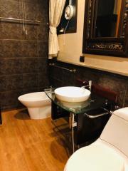 Modern bathroom with elegant fixtures and dark tile walls