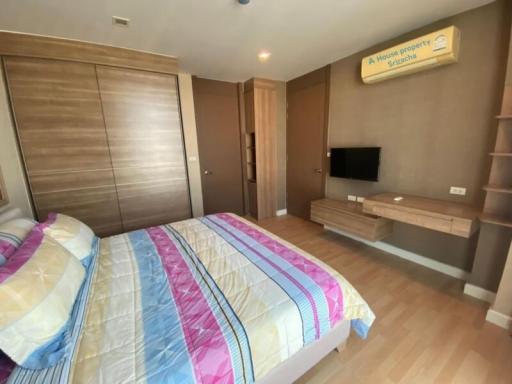 Spacious bedroom with wooden wardrobe and mounted television