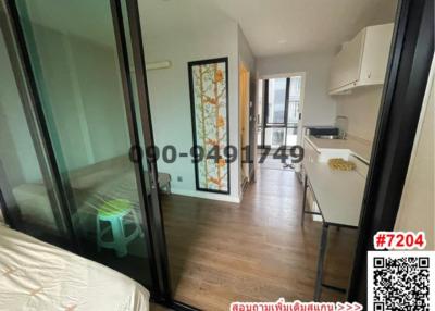 Compact bedroom with adjoining kitchen space and balcony access in modern apartment
