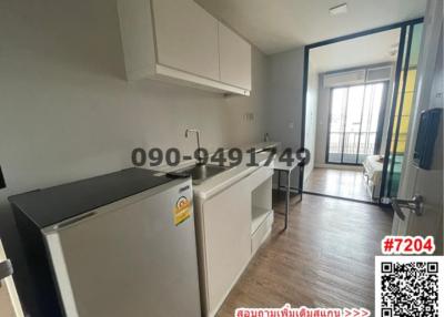 Compact kitchen with modern appliances next to a small dining area leading to a balcony