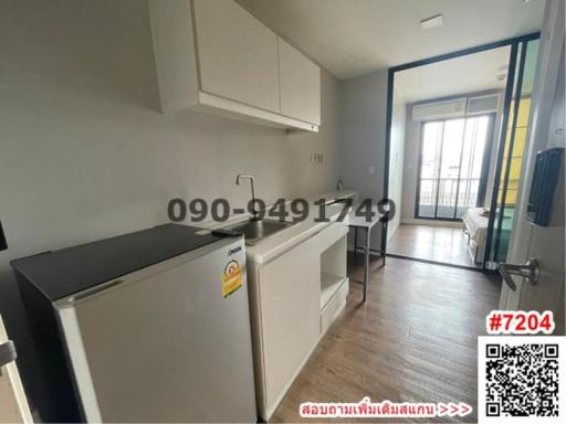 Compact kitchen with modern appliances next to a small dining area leading to a balcony