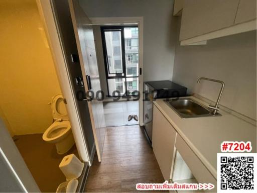 Compact bathroom with toilet and sink leading to a balcony