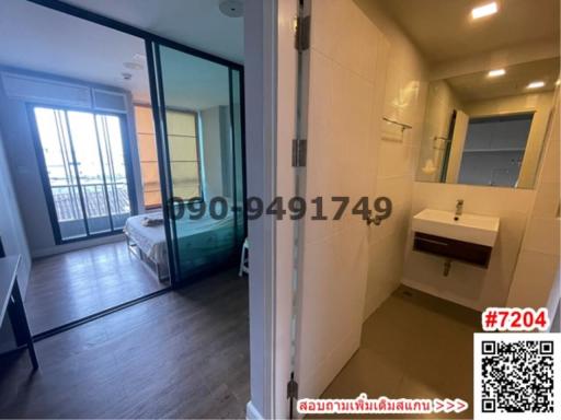 Modern bedroom connected to a bathroom with sliding glass doors and city view