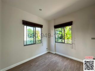 Spacious unfurnished bedroom with large windows and hardwood flooring