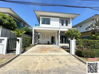 White two-story house with front yard and driveway