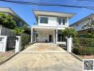 White two-story house with front yard and driveway