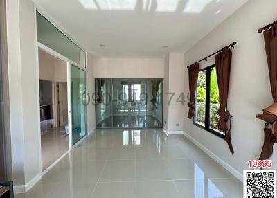 Spacious living room with large windows and tiled flooring
