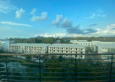 View from balcony overlooking residential buildings under clear blue sky