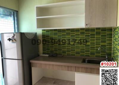 Modern kitchen with green tile backsplash and wooden countertop