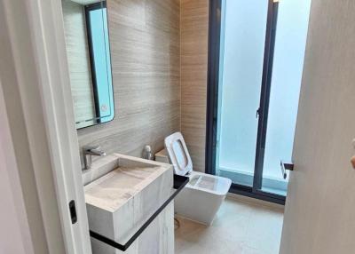 Modern bathroom interior with large mirror and glass door