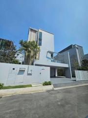 Modern two-story house with a clean architectural design and a spacious front yard