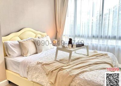 Elegantly furnished bedroom with a cozy bed and ample natural light
