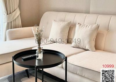 Modern living room with beige sofa and black round coffee table