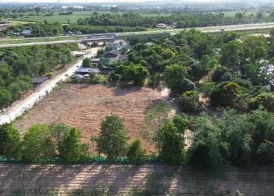 Aerial view of vacant land near a highway with surrounding greenery