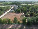 Aerial view of vacant land near a highway with surrounding greenery