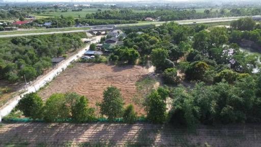 Aerial view of vacant land near a highway with surrounding greenery