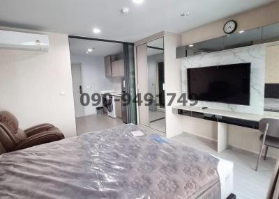 Compact bedroom with integrated living space including bed, wardrobe, TV unit and dining area
