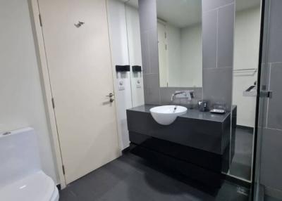 Modern bathroom interior with wall-mounted sink, toilet, and glass shower cubicle