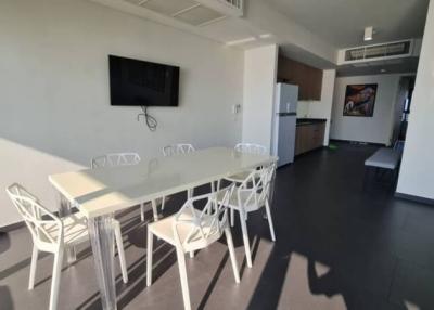 Modern open plan living and dining room with kitchen in the background