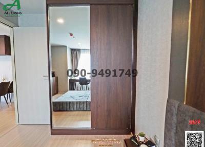 Modern bedroom with sliding wardrobe doors and a glimpse into the living area