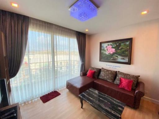 Elegant living room with comfortable sofa, natural lighting, and balcony access