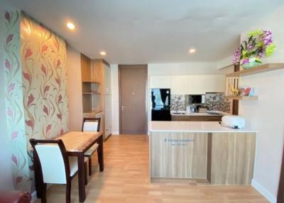 Modern kitchen with dining space featuring elegant wooden furniture and patterned wallpaper