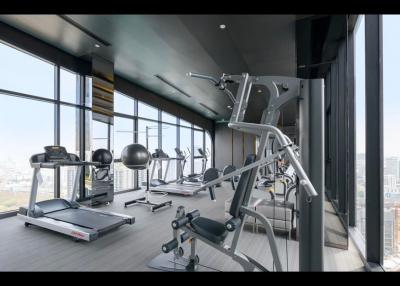 Modern gym with cardio and weightlifting equipment in a high-rise building with city views