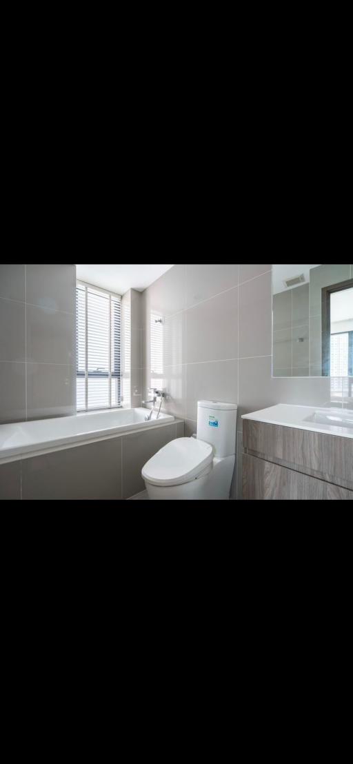 Modern bathroom with bathtub and neutral color tiles