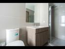 Modern bathroom with glass shower and wooden vanity