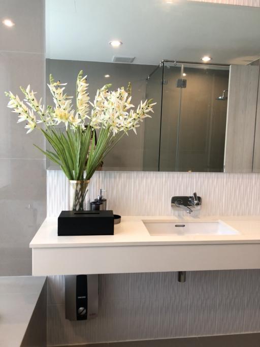 Modern bathroom interior with a sink, mirror, and decorative flowers