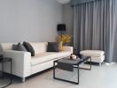 Modern living room with a white sofa, matching armchair, and elegant decor