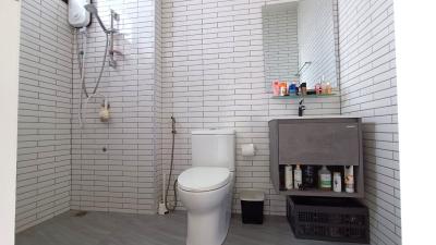 Modern white-tiled bathroom with shower and storage space