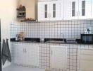 Modern kitchen with white cabinetry and black countertop