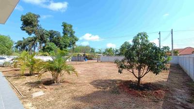 Spacious backyard with greenery and clear skies