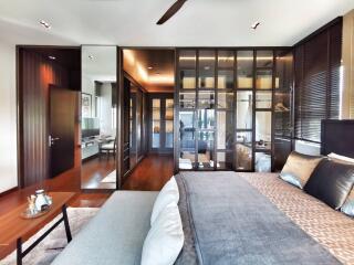 Elegant bedroom with wooden floor and modern furnishings connecting to an ensuite bathroom