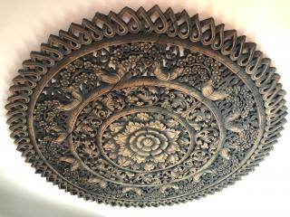 Intricate wooden carving on a wall or ceiling, possibly a decorative element in a home