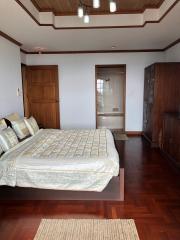 Spacious master bedroom with hardwood floors and an en-suite bathroom