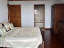 Spacious master bedroom with hardwood floors and an en-suite bathroom